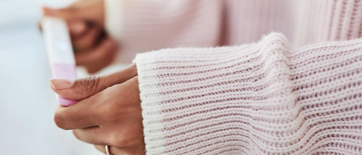 Close up of married woman’s hands holding a pregnancy test