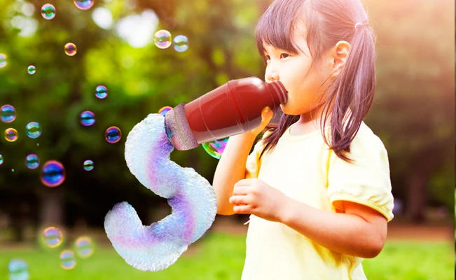 Young girl making a rainbow bubble snake