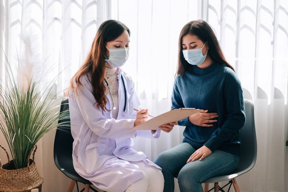 Doctor with Mask and Patient Discussing in Clinic