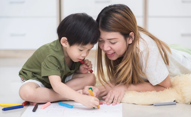 Mother and child coloring on the floor