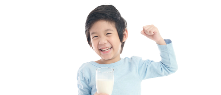 Happy child holding glass of milk and flexing arm showing strength