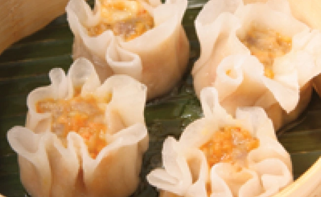 Four pieces of pork and shrimp siomai in dimsum container.