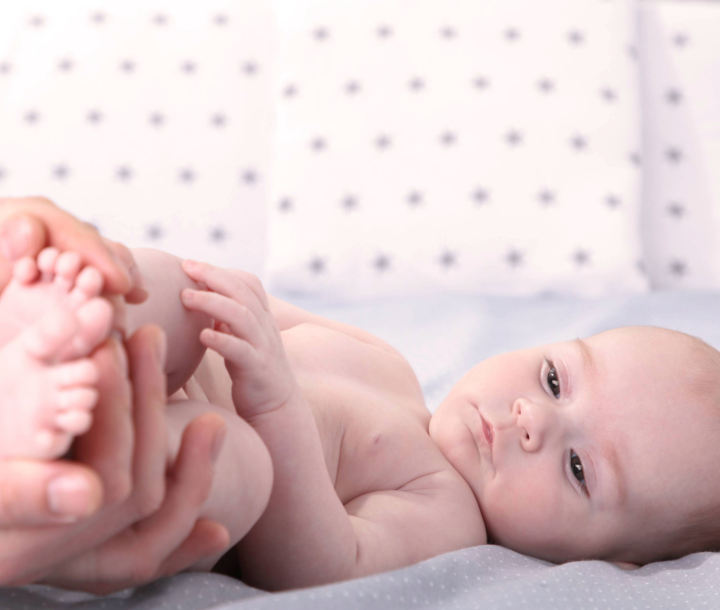 Médico pediatra revisando a un recién nacido, destacando la importancia de elegir al pediatra adecuado para el cuidado del bebé.