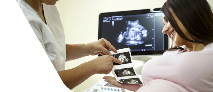 Pregnant patient having an ultrasound while looking at a sonogram