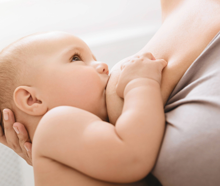 Bebé recién nacido alimentándose con calostro, la primera leche materna rica en nutrientes y defensas.