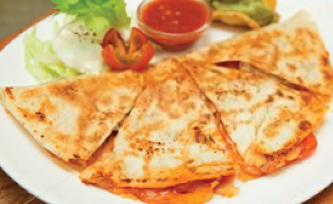 Picture of a half moon pizza on platter with food decor and dipping sauce