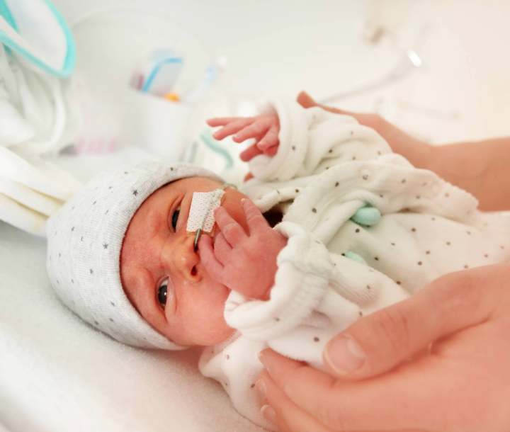 Bebé prematuro con gorro en casa.