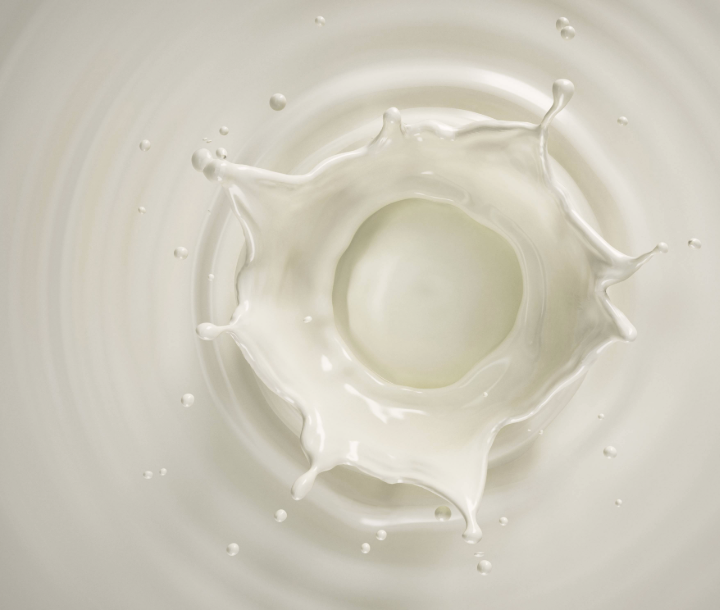 Chorro de leche cayendo en un recipiente, ilustrando la alergia a la proteína de la leche de vaca (APLV)