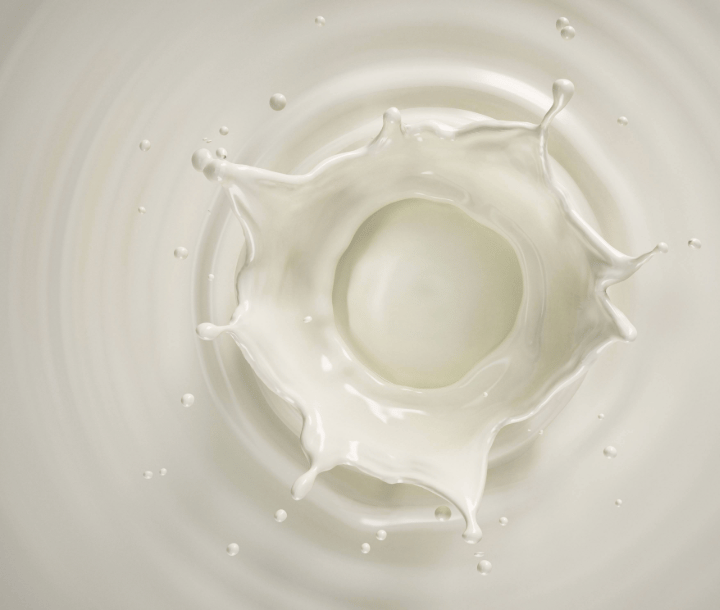 Chorro de leche cayendo en un recipiente, ilustrando la alergia a la proteína de la leche de vaca (APLV)