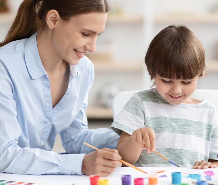 Madre jugando y enseñando a su hijo con piezas de colores, representando el rol del MFGM en la nutrición infantil.