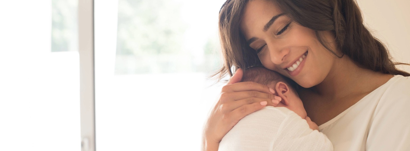 Madre con su bebé recién nacido en brazos en la página de bienvenida de Enfabebé, programa de acompañamiento para padres en los primeros días.