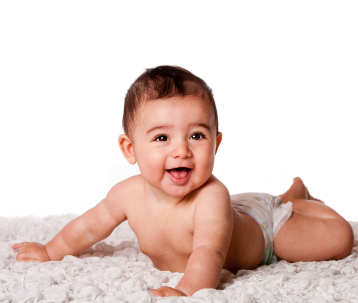 Bebé sonriente acostado boca abajo, símbolo de estimulación temprana y desarrollo saludable.