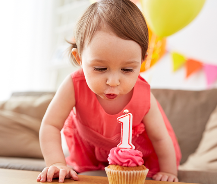 Escenario decorado con globos y estrellas doradas para celebrar el primer cumpleaños de un bebé.