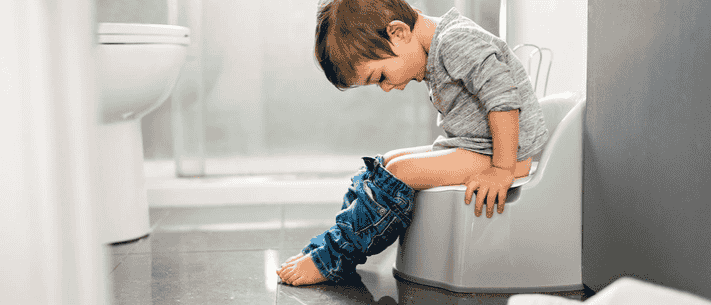 Toddler Sitting on a Potty in Bathroom with Pensive Expression