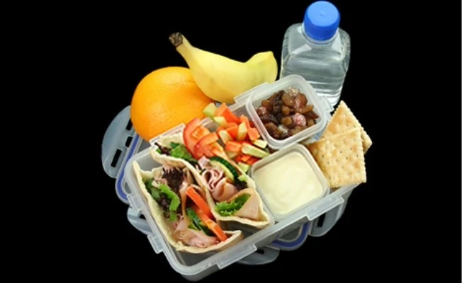 Lunchbox with wrap, salad, fruit, crackers, and water bottle