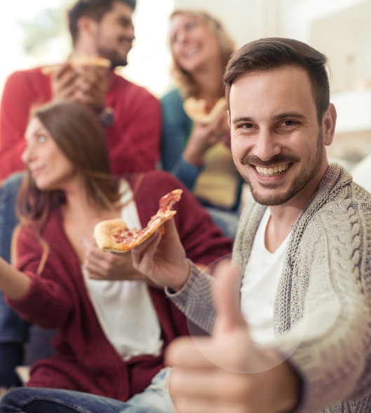 בחור צעיר אוכל פיצה עם חברים