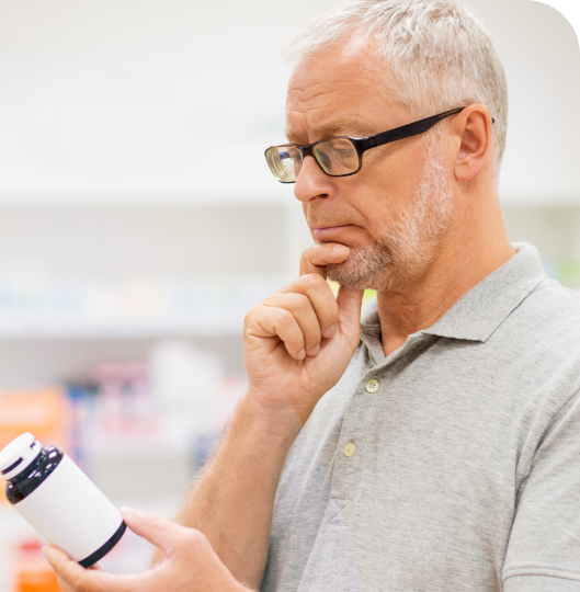 A men reads the drug labels A men reads the drug labels