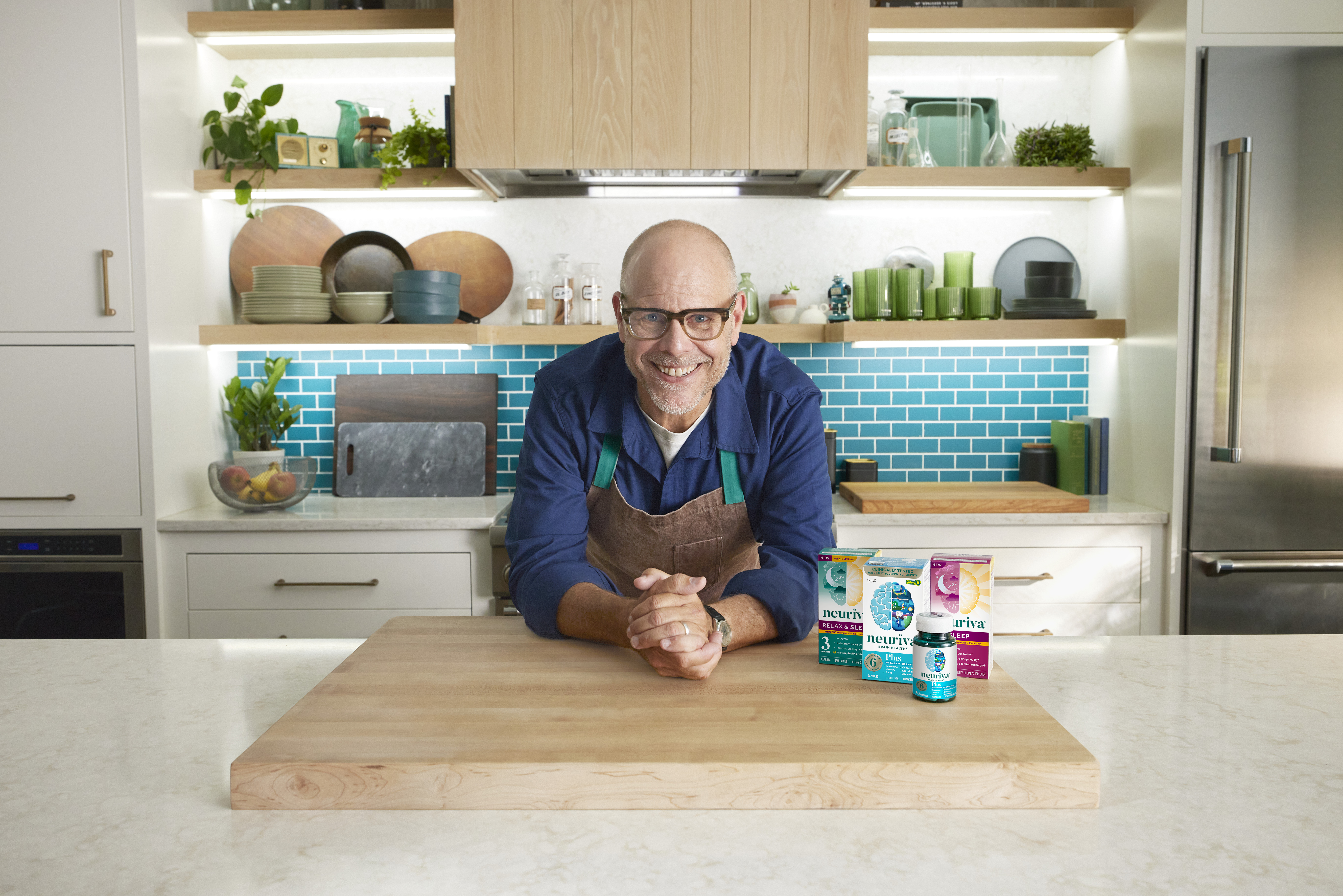Person smiling in a kitchen beside Neuriva Brain Health products displayed on a countertop