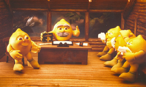 Animated characters shaped like lozenges gathered in a wooden room, one leading a meeting.