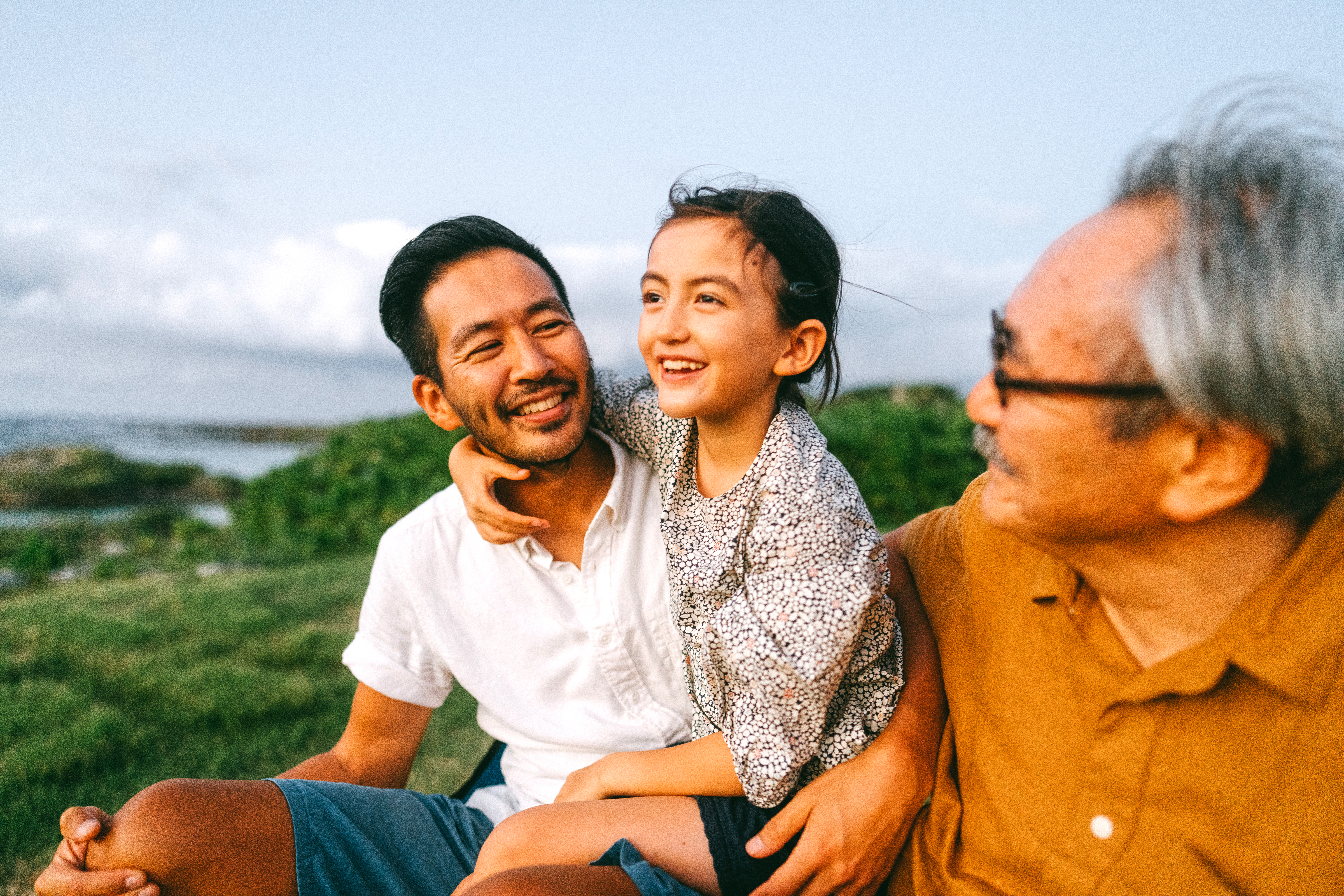 Family sitting together outdoors, smiling and talking