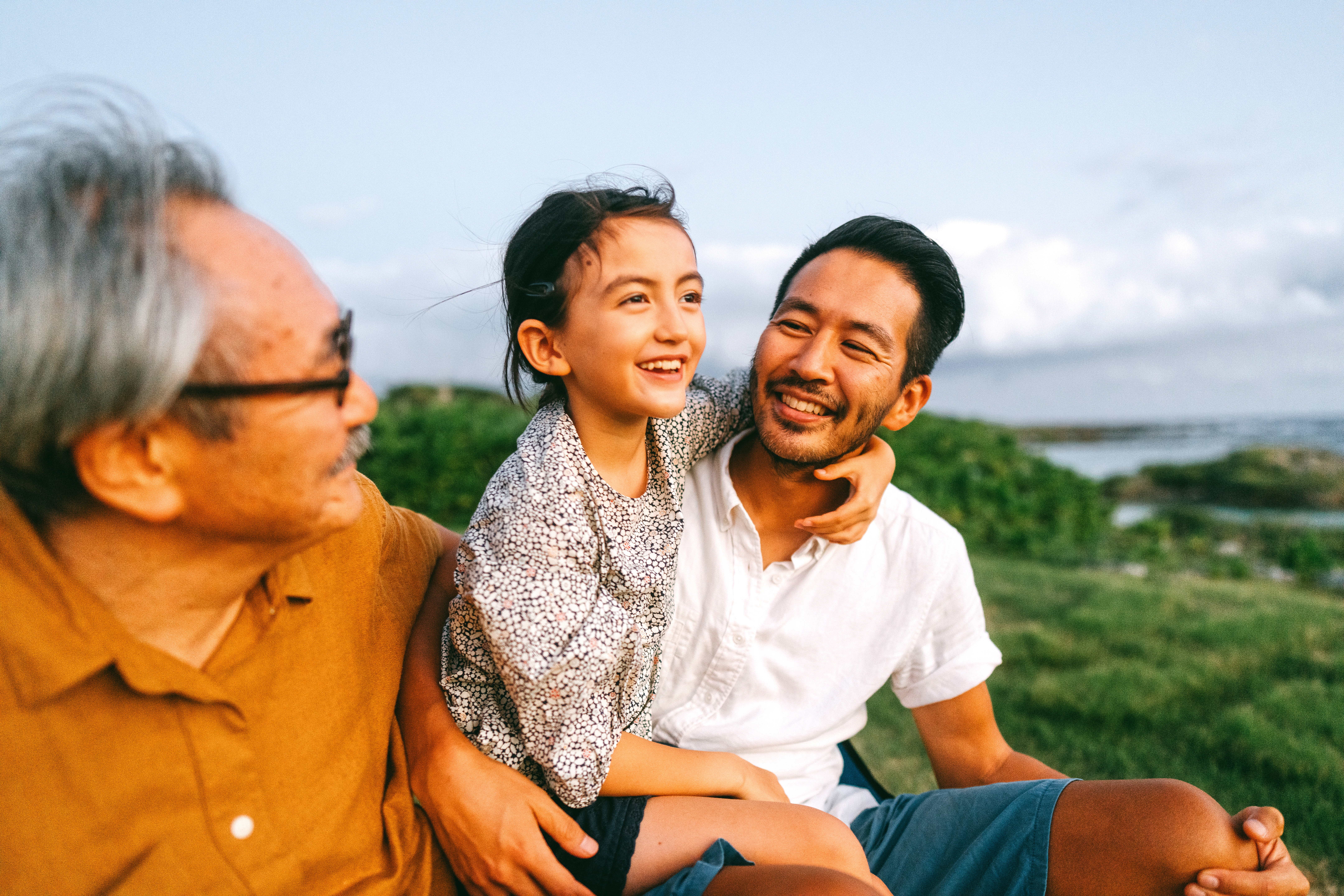Family sitting together outdoors, smiling and talking
