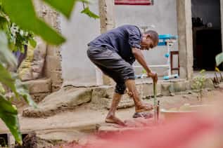 Man washing his foot with water from an outdoor tap