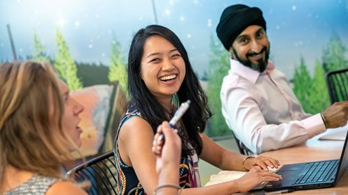 Diverse group of employees sitting around table in a meeting room