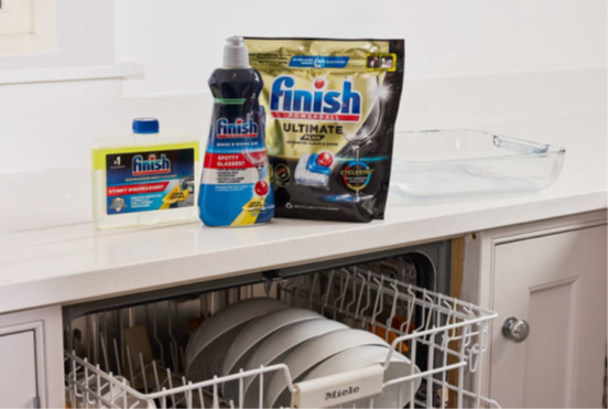 Open dishwasher with Finish detergent on the counter
