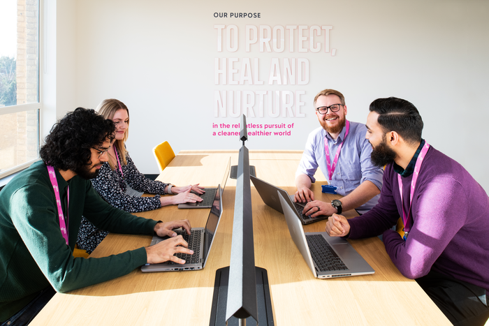 Team working on laptops at a shared office table