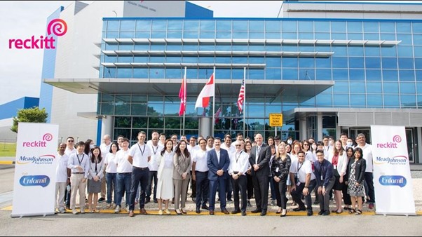 Employees and partners gathered outside a Reckitt manufacturing facility during a corporate event