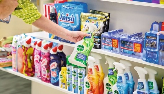 Shopper browsing Reckitt household cleaning products on store shelves