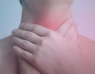 An up-close view of a person clutching their neck with both hands, featuring a soft red overlay on the throat area.