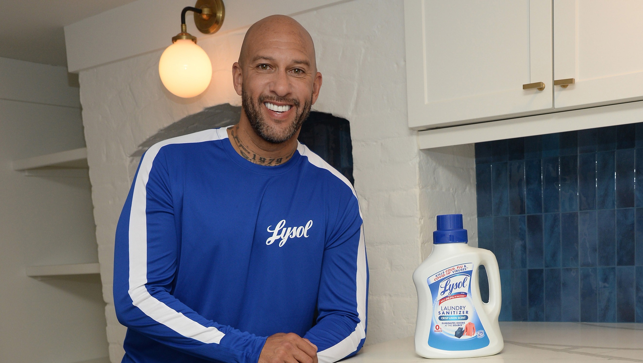 Person standing beside a bottle of laundry sanitizer in a kitchen
