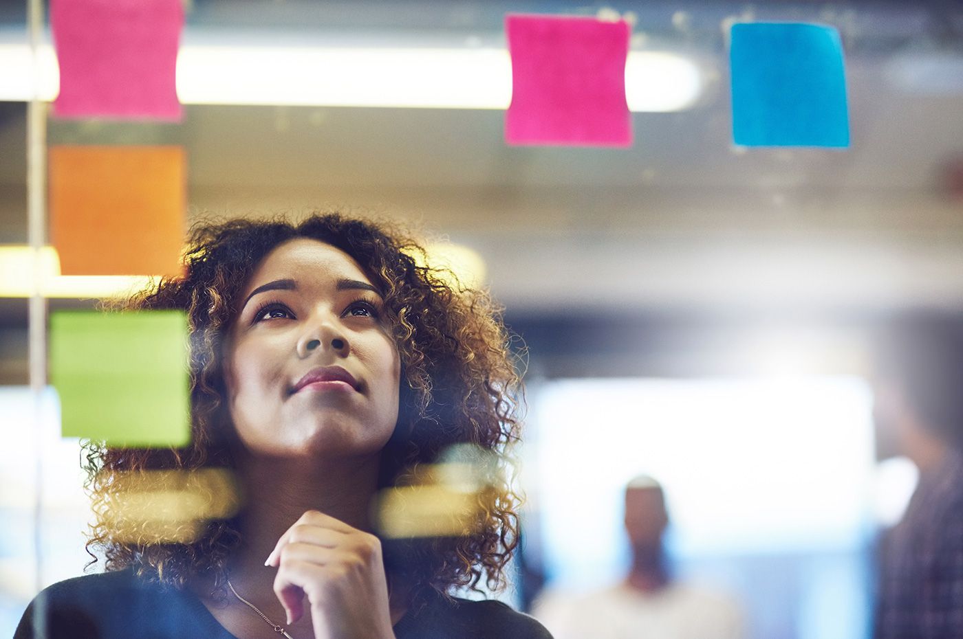 Professional reviewing ideas on sticky notes during a brainstorming or planning session