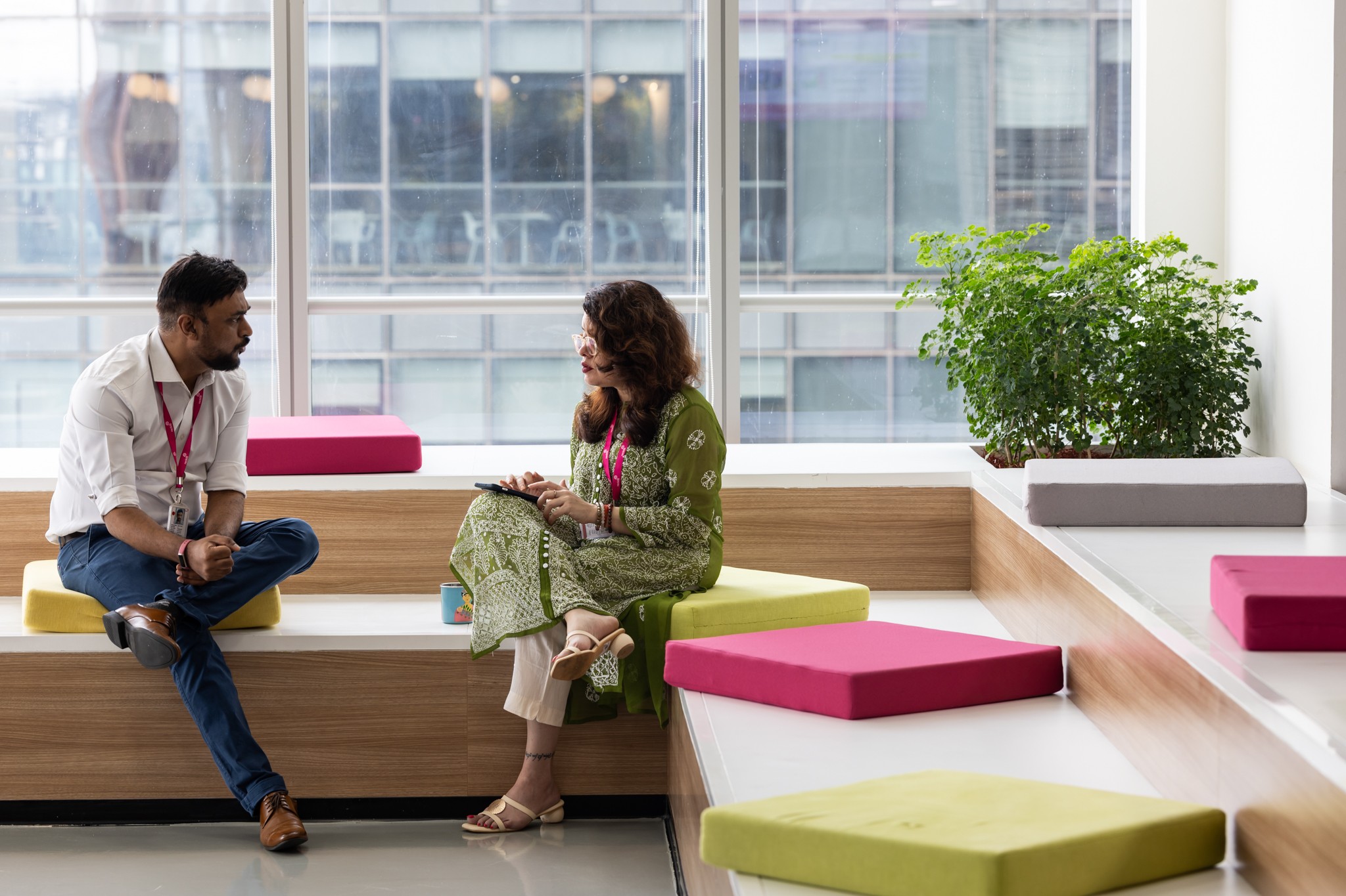 Two colleagues talking while seated in a bright office space