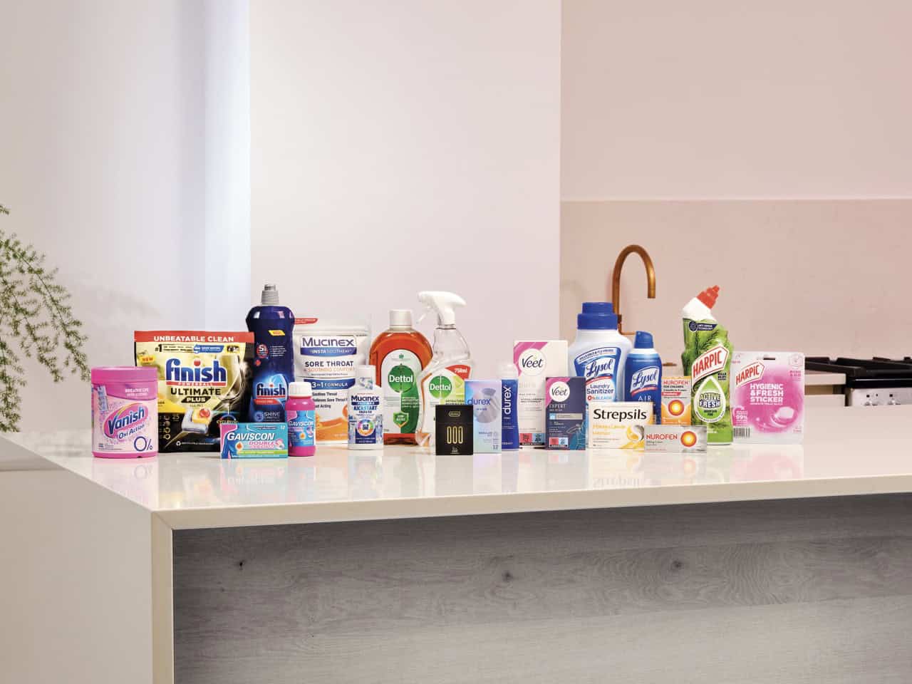Assortment of household cleaning and healthcare products displayed on a kitchen counter.