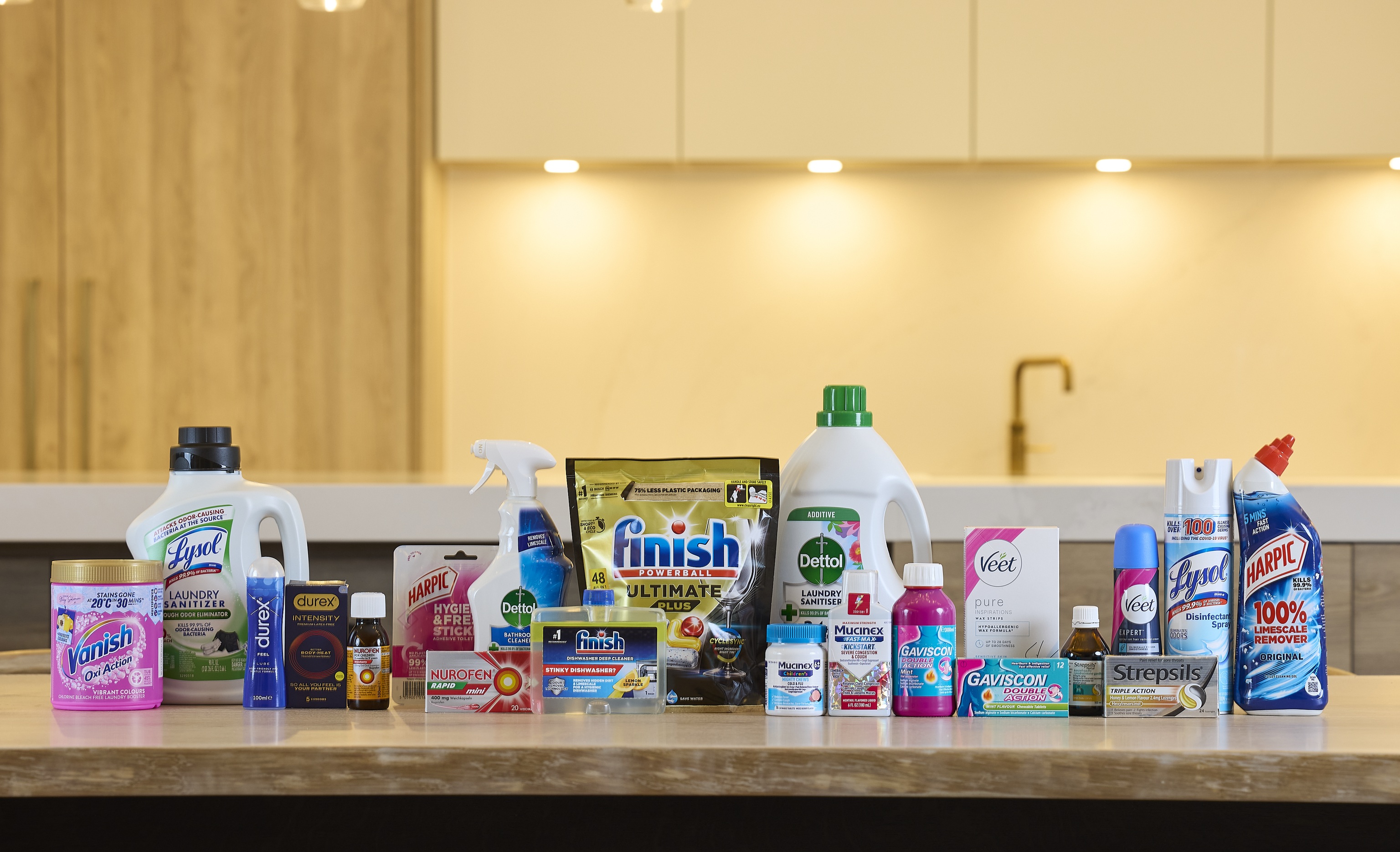 Assortment of household cleaning and healthcare products arranged on a kitchen counter.