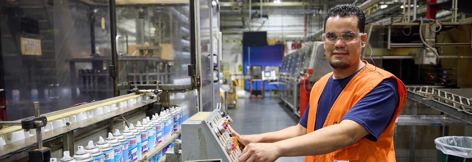 Factory worker operating machinery on a production line in an industrial facility