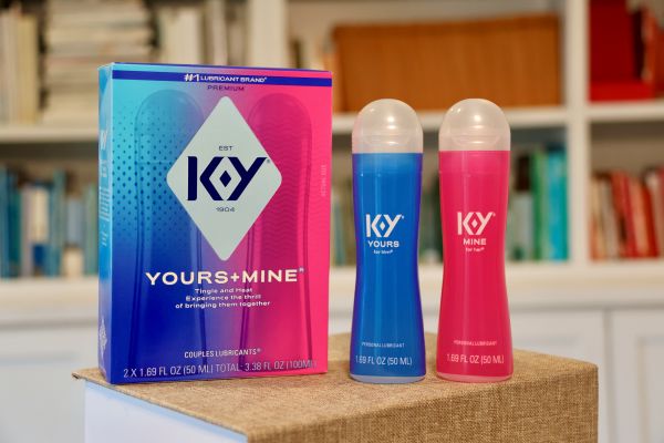 A box of K-Y Yours+Mine Couples Lubricants stands next to two separate blue and pink lubricant bottles on a small pedestal.