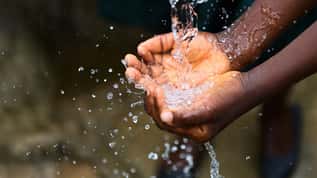 Hands catching and splashing clean water