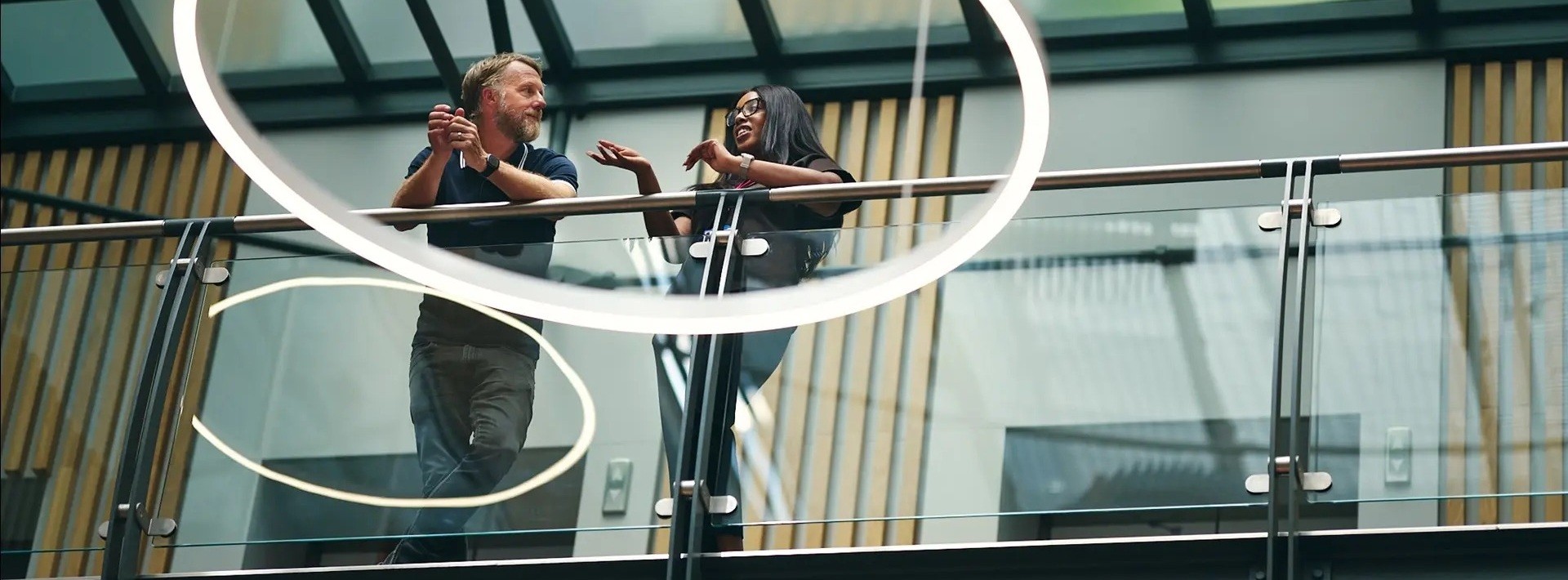 Two colleagues talking on a modern office balcony