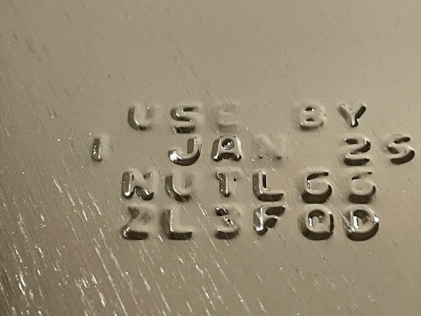Embossed lot code and manufacturing date markings stamped on product packaging
