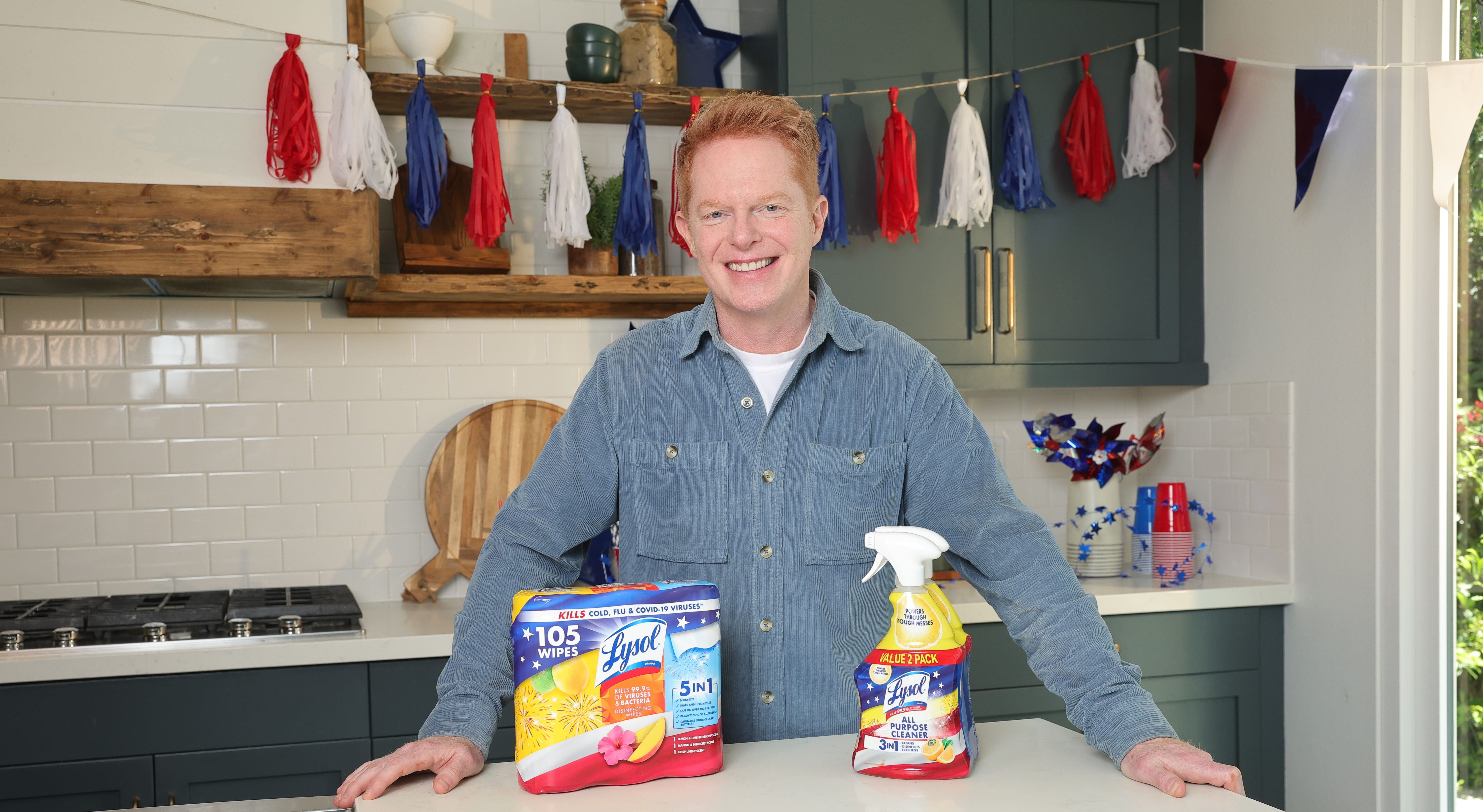Person standing in a decorated kitchen beside cleaning products