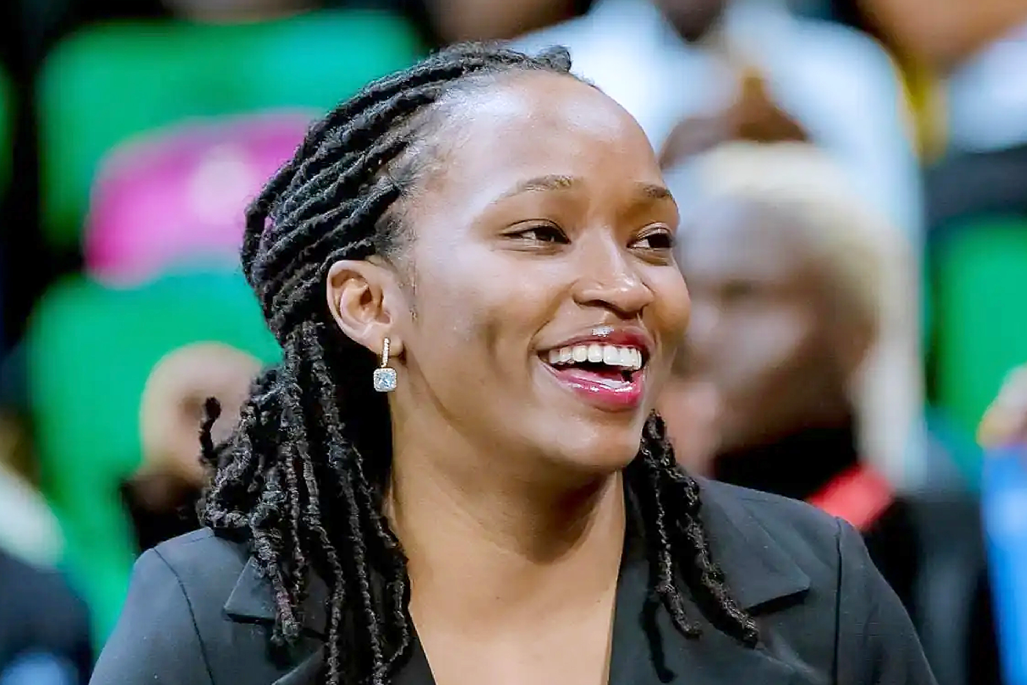 Smiling woman with braided hair in a crowd
