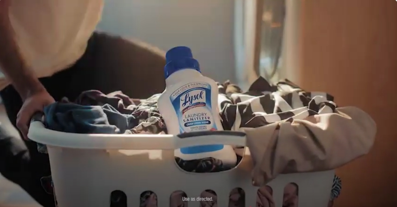 Lysol Laundry Sanitizer displayed in a laundry basket filled with clothes, highlighting fabric sanitization during laundry care routines