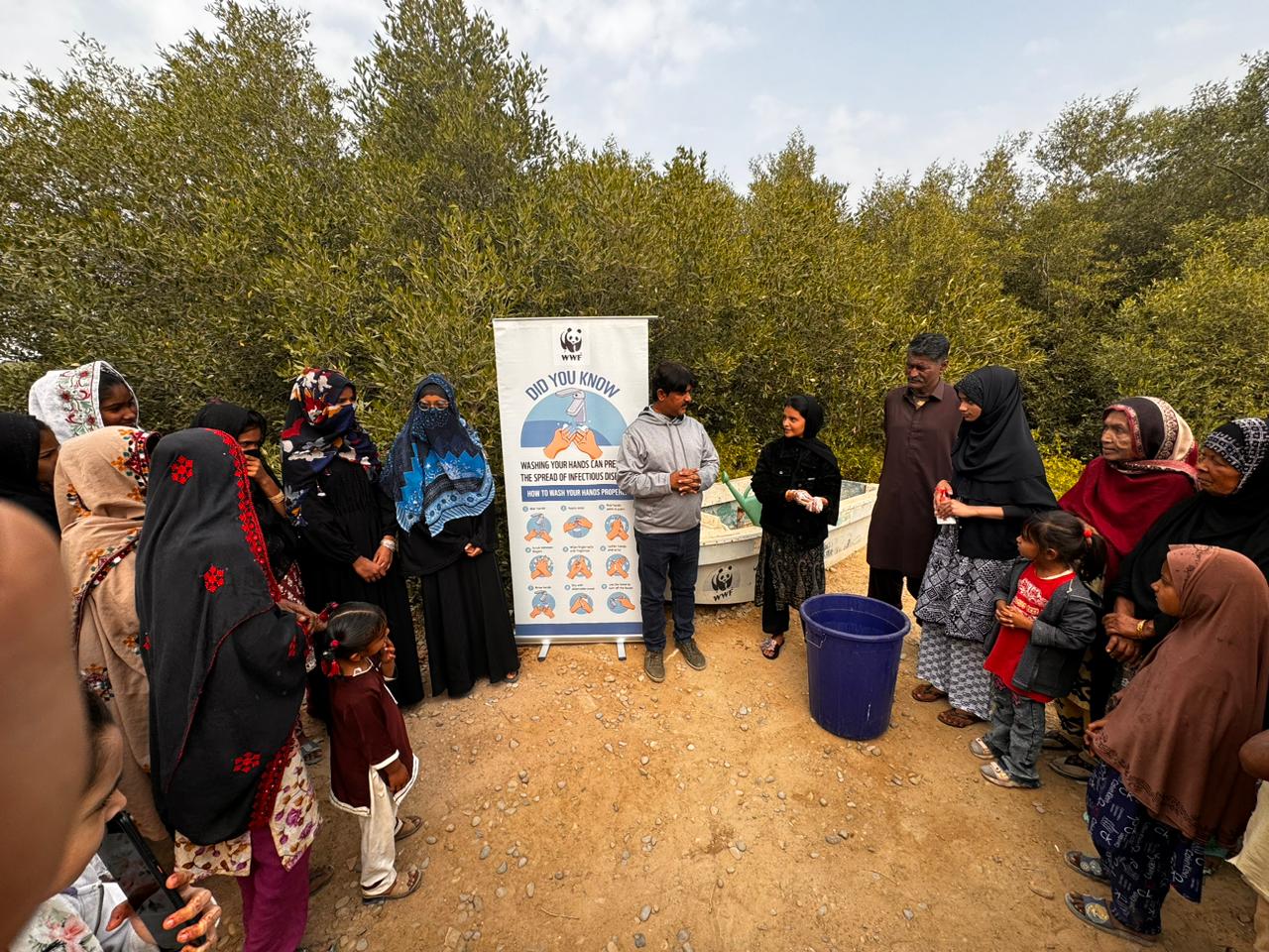 Community group gathered around a handwashing awareness demonstration