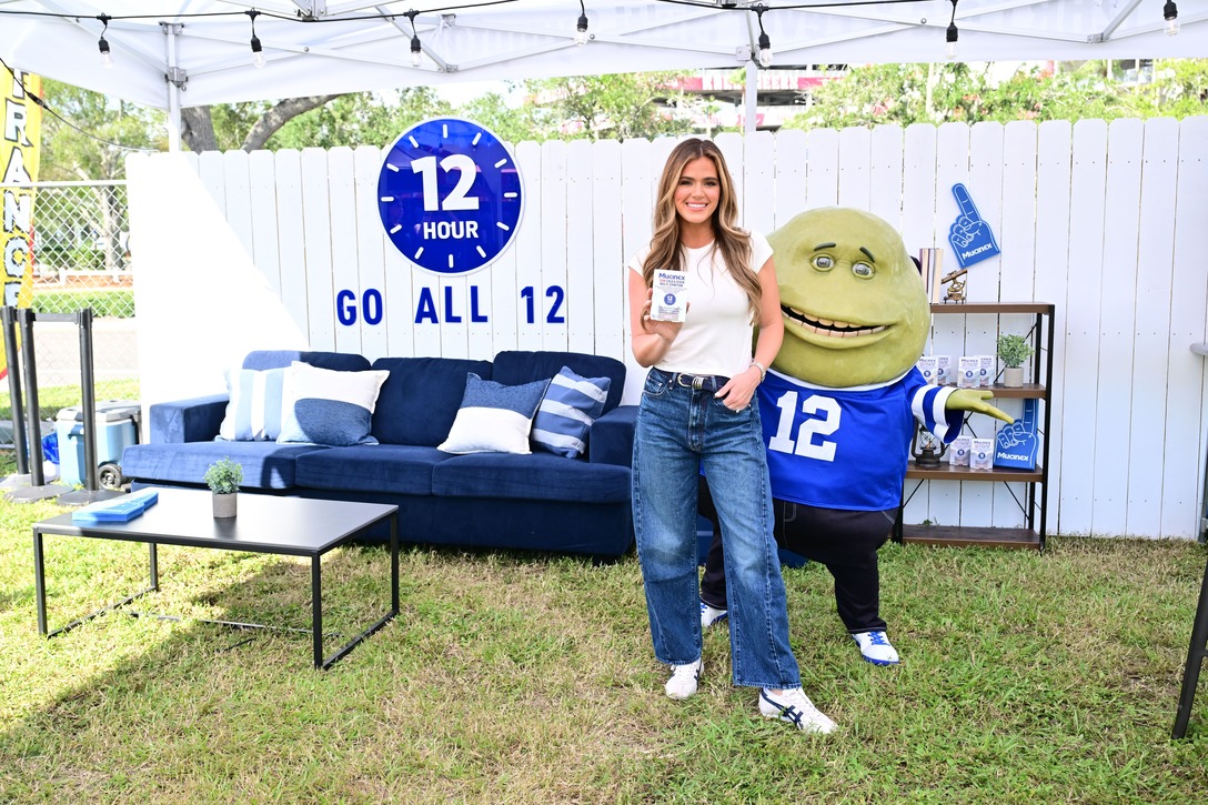 A Mucinex promotional setup featuring the 12-hour campaign, a product display, and the brand mascot