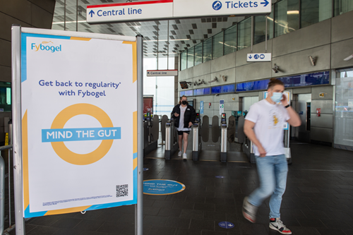 Man walking near to the banner "MIND THE GUT"