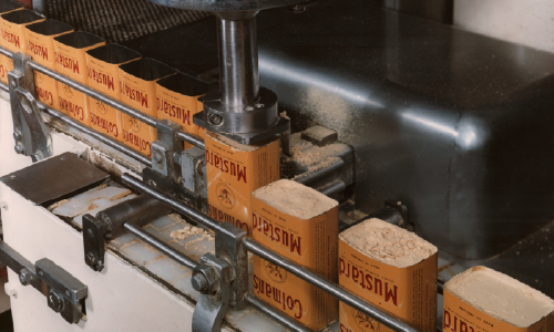 Manufacturing line producing Mucinex boxes on a packaging conveyor.