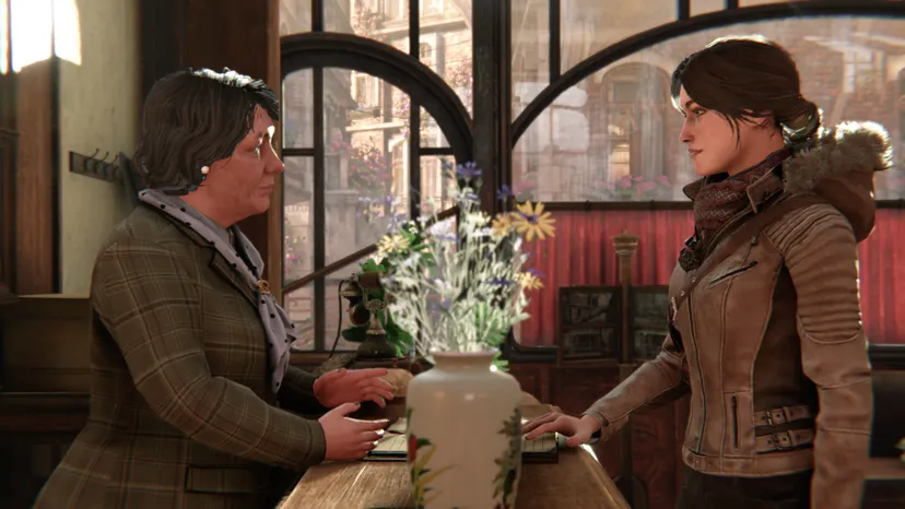 Syberia protagonist Kate Walker greets a woman at a counter.